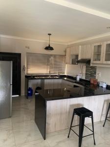a large kitchen with a counter and a refrigerator at Greendale Apartments in Lusaka