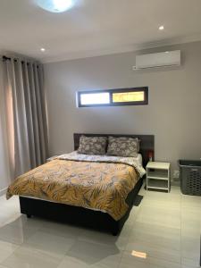 a bedroom with a bed and a window at Greendale Apartments in Lusaka