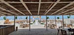 ein Restaurant mit Tischen und Stühlen sowie einem Spielplatz in der Unterkunft Iaki Conference & Spa Hotel in Mamaia