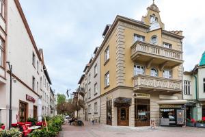 un edificio amarillo con balcón en una calle en Happy Stay Apartments Sopot Bema, en Sopot