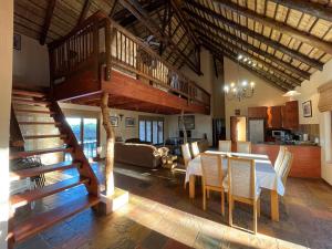a large living room with a table and a staircase at Sondela Nature Reserve & Spa Makhato Lodges in Bela-Bela
