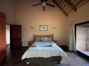 a bedroom with a bed and a ceiling fan at Sondela Nature Reserve & Spa Makhato Lodges in Bela-Bela