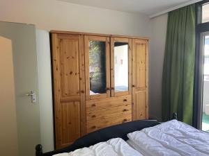 een slaapkamer met een houten kast naast een bed bij Ferienwohnung Memory in Bad Harzburg +16 foto's