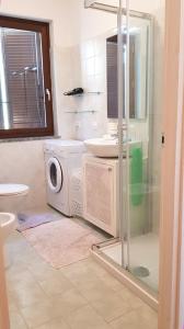 a bathroom with a washing machine and a sink at La Quiete 08 lake view Apartment By Garda Domus Mea in Tremosine Sul Garda