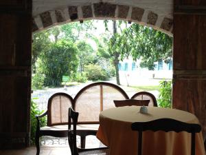 a table and chairs on a porch with an archway at Charqueada Santa Rita Pousada de Charme in Pelotas