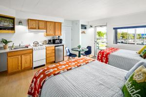 a room with two beds and a kitchen with a sink at Seascape Motel & Cottages in Belfast