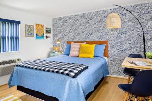 Un dormitorio con una cama azul con una almohada azul y amarilla en Seascape Motel & Cottages, en Belfast