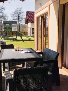 a table and chairs on a patio with a playground at Kubiczówka in Kopalino +9 photos