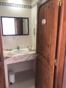a bathroom with a sink and a wooden door at Vinha da Quinta in Sintra