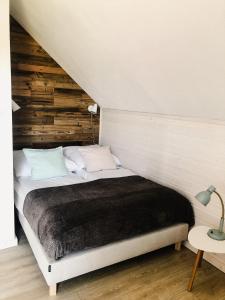 a bedroom with a bed with a wooden wall at Kubiczówka in Kopalino