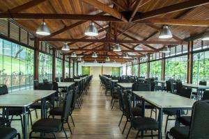 a row of tables and chairs in a room with windows at Sesc Venda Nova in Belo Horizonte