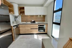 una cocina con armarios blancos y fregadero en Mereani flat brand new condo in the center of Papeete en Papeete
