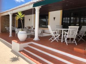 a patio with white chairs and tables on a house at Vinha da Quinta in Sintra