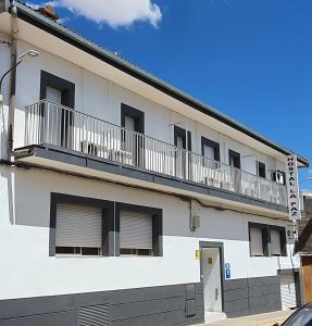 ein weißes Gebäude mit Balkon darüber in der Unterkunft Hostal La Paz in Ossa de Montiel