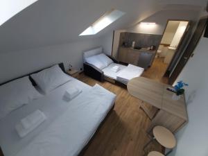 um pequeno quarto com duas camas e uma mesa em Apartamenty MARGO em Chrzanów