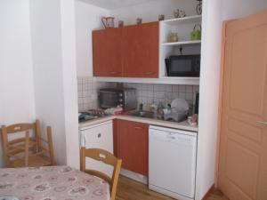 uma pequena cozinha com um lavatório e um micro-ondas em Appartement T3 neuf au frais à la montagne em Puy-Saint-Vincent
