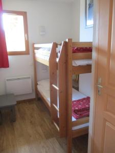 Cette chambre comprend 2 lits superposés et une fenêtre. dans l'établissement Appartement T3 neuf au frais à la montagne, à Puy-Saint-Vincent