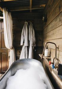 a tub filled with snow next to a wooden wall at The Workers Cottage in Great Bircham