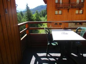 d'une table et de chaises sur un balcon avec vue. dans l'établissement Appartement T3 neuf au frais à la montagne, à Puy-Saint-Vincent