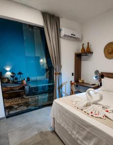 Malai Boutique Hotel في فورتاليزا: غرفة نوم بسرير ونافذة زجاجية كبيرة