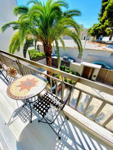 a balcony with a table and a palm tree at Phoenix Garden Apartments II in Athens