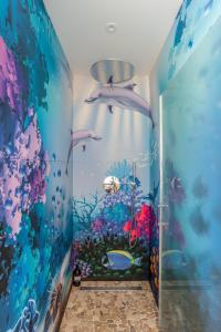 ein Bad mit einem Wandbild eines Aquariums in der Unterkunft KER MANOU - Baie des dauphins in Cancale