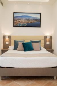 a bedroom with a large bed with a picture on the wall at Paradise Sicily Rooms in Calatabiano