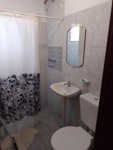 a bathroom with a sink and a toilet and a mirror at Alojamiento económico de buena ubicación in Gualeguaychú +6 photos