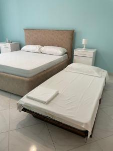 two beds sitting next to each other in a bedroom at DANTE APARTAMENT in Vlorë
