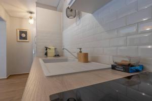 uma cozinha com um balcão branco e um lavatório em CABANA & La Calade - Centre-Ville em Villefranche-sur-Saône