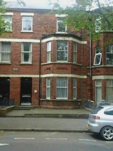 un bâtiment en briques avec une voiture garée devant lui dans l'établissement Eglantine Townhouse, à Belfast