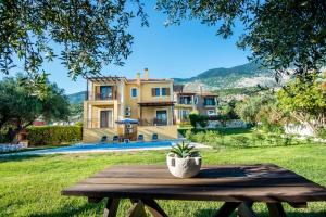 a wooden table in front of a house at VILLA IRIDA in Kefallonia