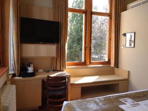 een hotelkamer met een bureau en een raam bij Boutique hotel Shamon in Eeklo