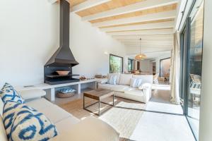 sala de estar con muebles blancos y chimenea en Villa Es trenc - Can Riera en Campos