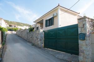 a house with a green garage door on a street at Kiveri Garden Villa in Kiveri