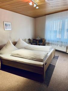 ein großes Bett in einem Zimmer mit Fenster in der Unterkunft Hotel Pension Balthasar in Müden