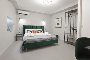 a bedroom with a green bed in a white room at Agrigento Chianu Palì - Guest Rooms camera Agrigento matrimoniale relax valle dei templi in Agrigento