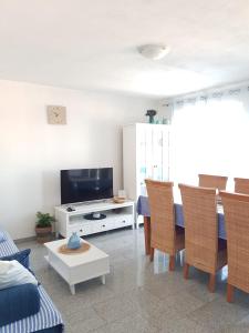 - un salon avec une télévision, une table et des chaises dans l'établissement Apartment Renata, à Senj