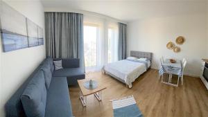 un soggiorno con un divano blu e un letto di Apartamenty Marea Rentals Aquarius Ustka a Ustka