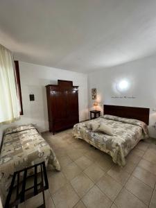 a bedroom with two beds and a dresser in it at Agriturismo Corte San Girolamo in Mantova