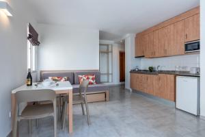cocina y sala de estar con mesa y sillas en Apartamentos Vista Club, en Santa Ponsa