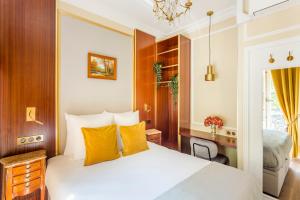 sypialnia z białym łóżkiem z żółtymi poduszkami w obiekcie Luxury 4 bedrooms 4 bathrooms apartment in Le Marais w Paryżu