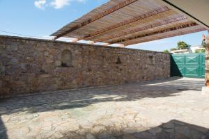 un muro in pietra con pergolato in legno di Kiveri Garden Villa a Kiveri