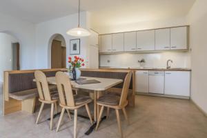 kuchnia i jadalnia ze stołem i krzesłami w obiekcie Residence Hof am Keller w mieście Montagna