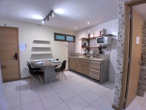 a kitchen with a table and chairs and a sink at Residence 207 Cabo Branco in João Pessoa