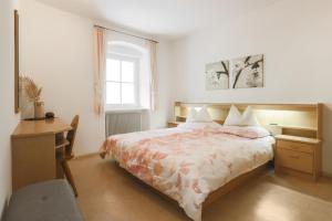 sypialnia z łóżkiem, biurkiem i oknem w obiekcie Residence Hof am Keller w mieście Montagna