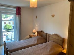 2 camas num quarto com uma janela em Appartement Brides-les-Bains, 3 pièces, 6 personnes - FR-1-512-148 em Brides-les-Bains