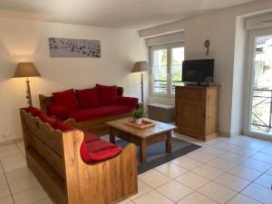 uma sala de estar com um sofá vermelho e uma televisão em Appartement Brides-les-Bains, 3 pièces, 6 personnes - FR-1-512-148 em Brides-les-Bains