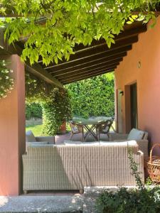 a patio with a table and chairs under awning at Garda Golf Country Chic Home in Soiano del Lago