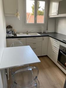 a kitchen with two chairs and a white counter top at Appartement de deux chambres au calme in Nozay